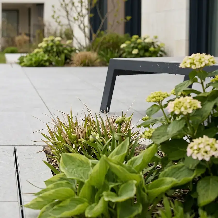 Un zoom sur une terrasse construite avec des dalles de gré cérame gris clair pour un pavillon au Luxembourg.