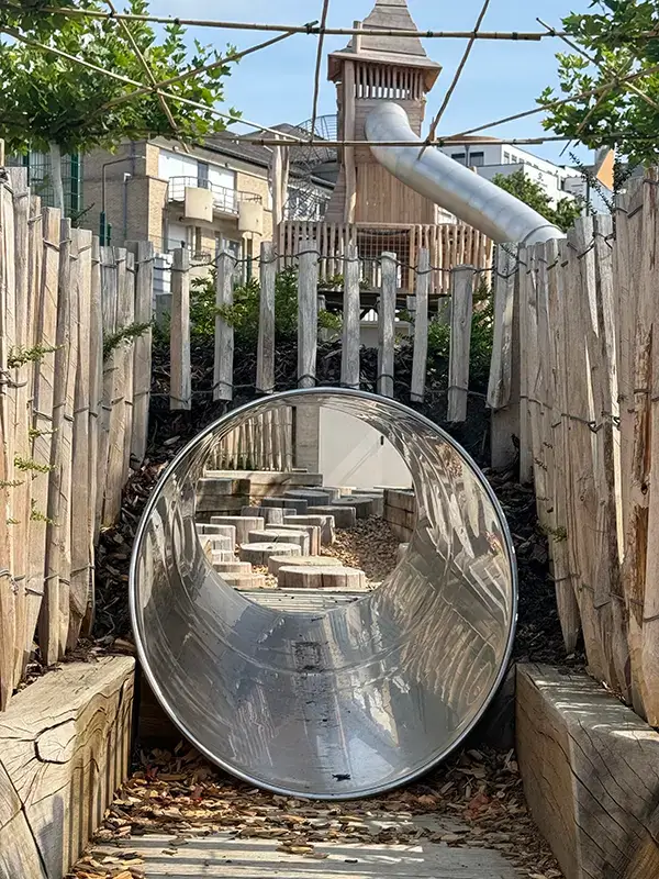 Une image en immersion dans la structure de jeux : toboggan, ganivelles, toiture végétalisée.